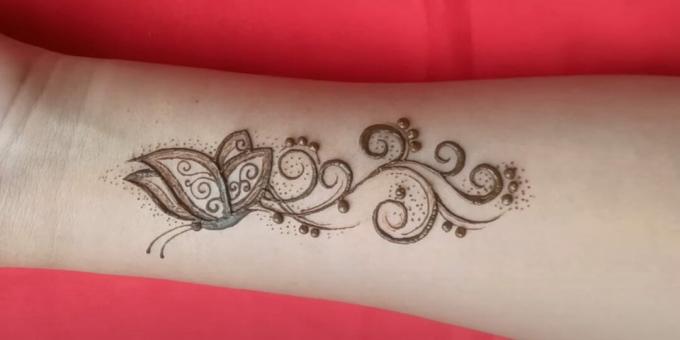 Dibujo de mariposa de henna en la mano: decora el tatuaje con puntos