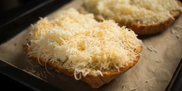 Cómo hacer picatostes de queso con ajo: espolvorear el queso sobre el pan y hornearlo