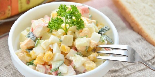 Ensalada con palitos de cangrejo, maíz y huevos